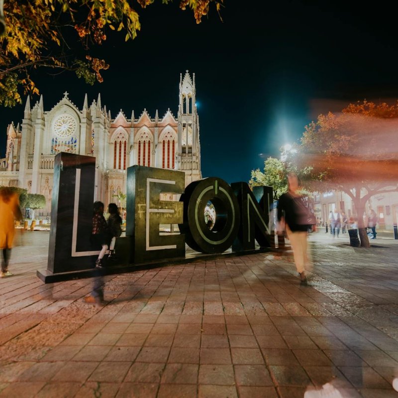Vibrant night view of León's iconic cathedral with blurred motion of people, captured in México.